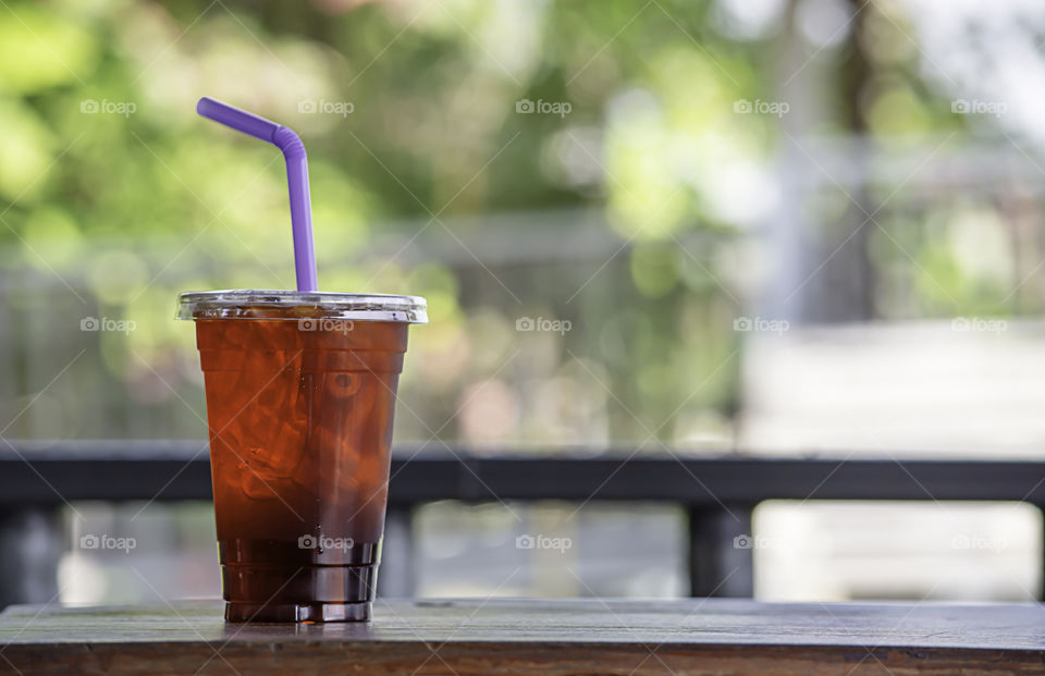 Iced tea in a glass on the wooden table.