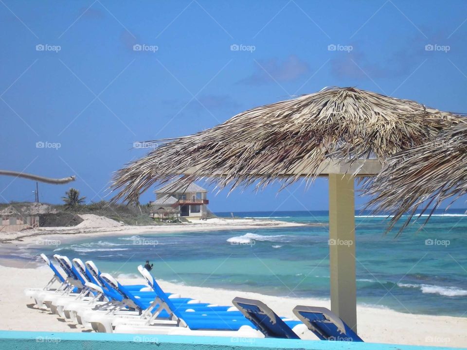 Grand Cayman’s Beautiful Pristine Beaches Perfect for Lounging Under a Grass Umbrella 