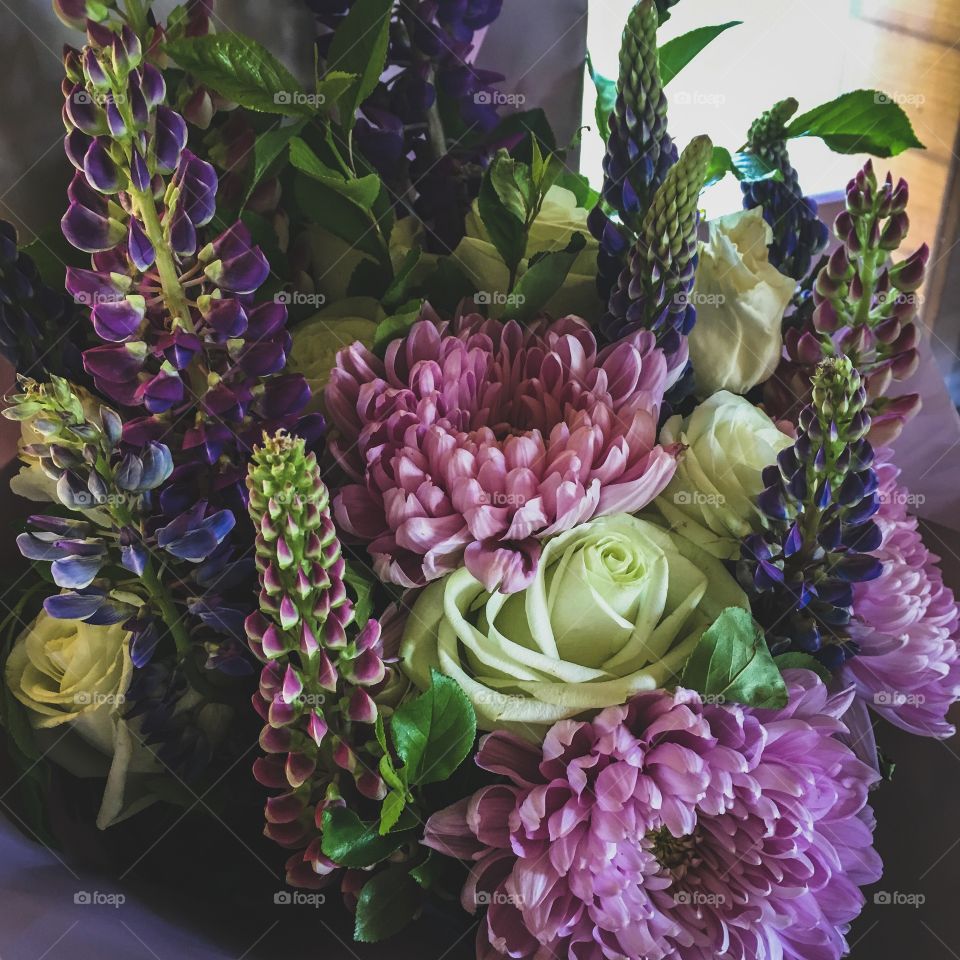 background beautiful summer bouquet of flowers from tender violet chrysanthemums, white roses and lupines