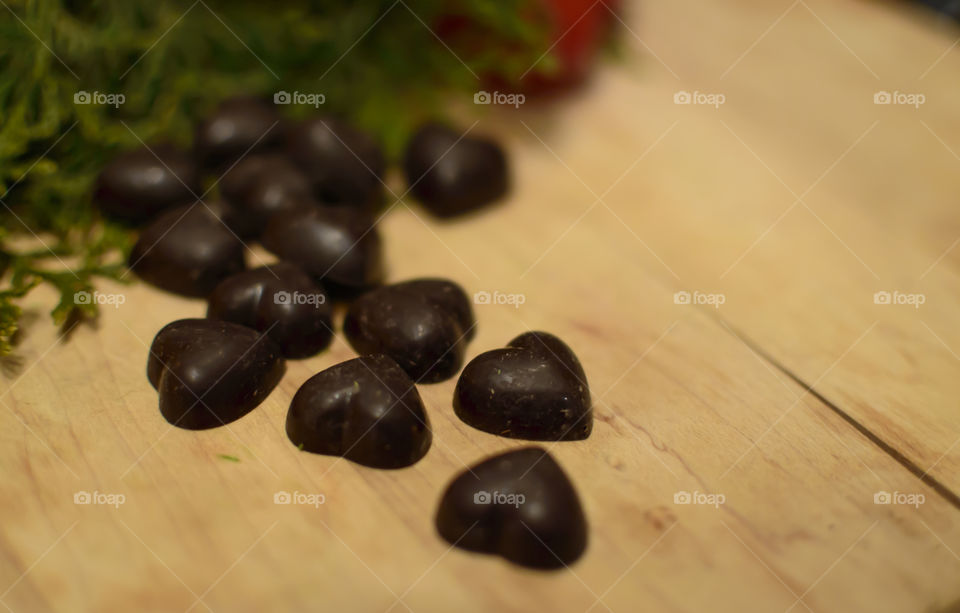 Dark chocolate hearts on wood background 