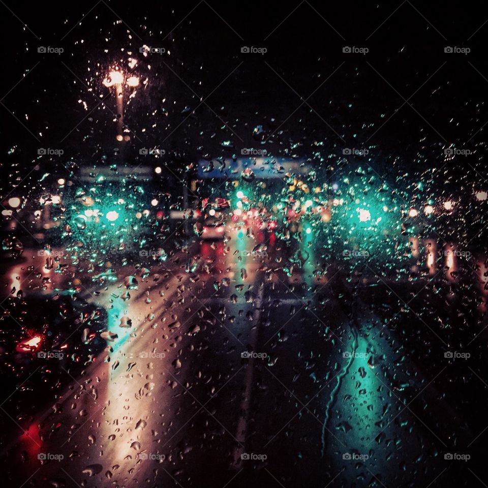 Raindrops on window glass at night in the city