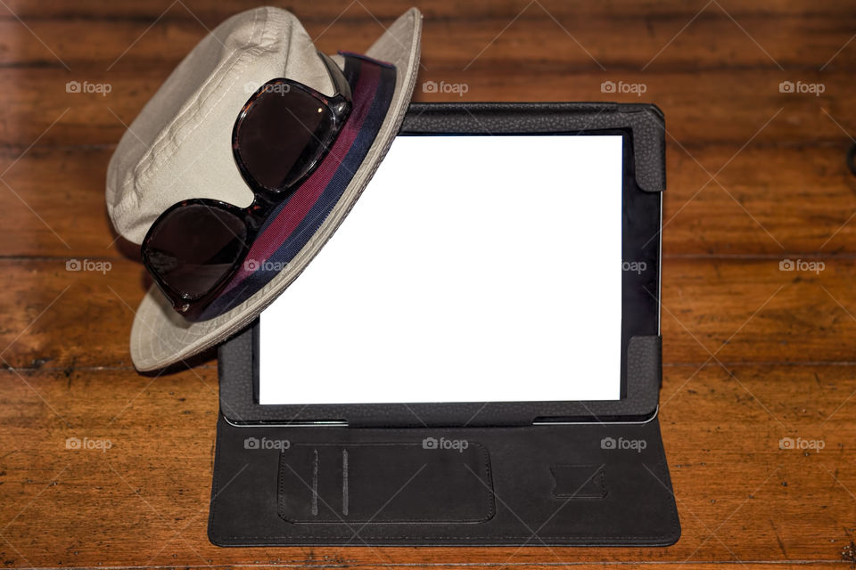 Fedora and sunglasses on digital tablet