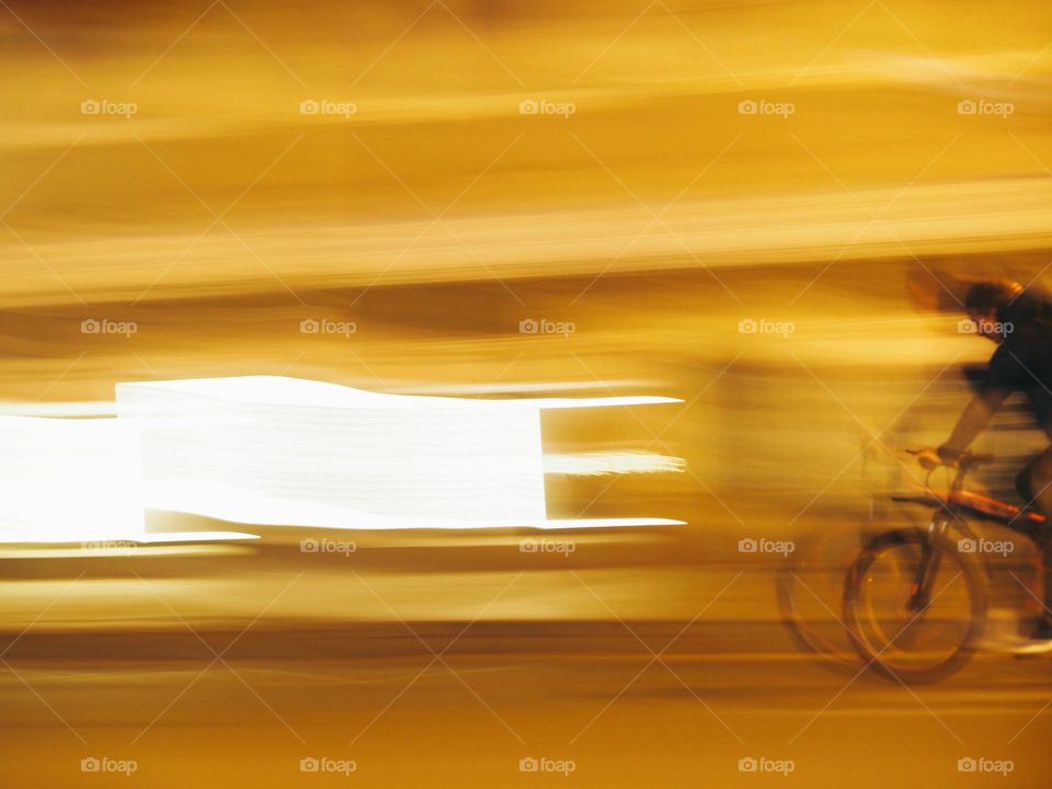 Men on a bicycle riding on night street, long exposure 