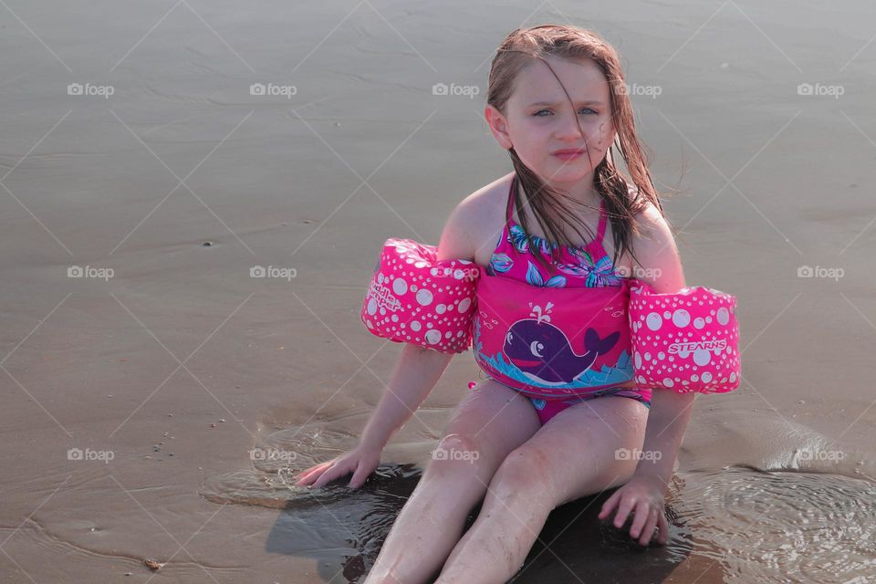 blue eyes sitting in the sand.