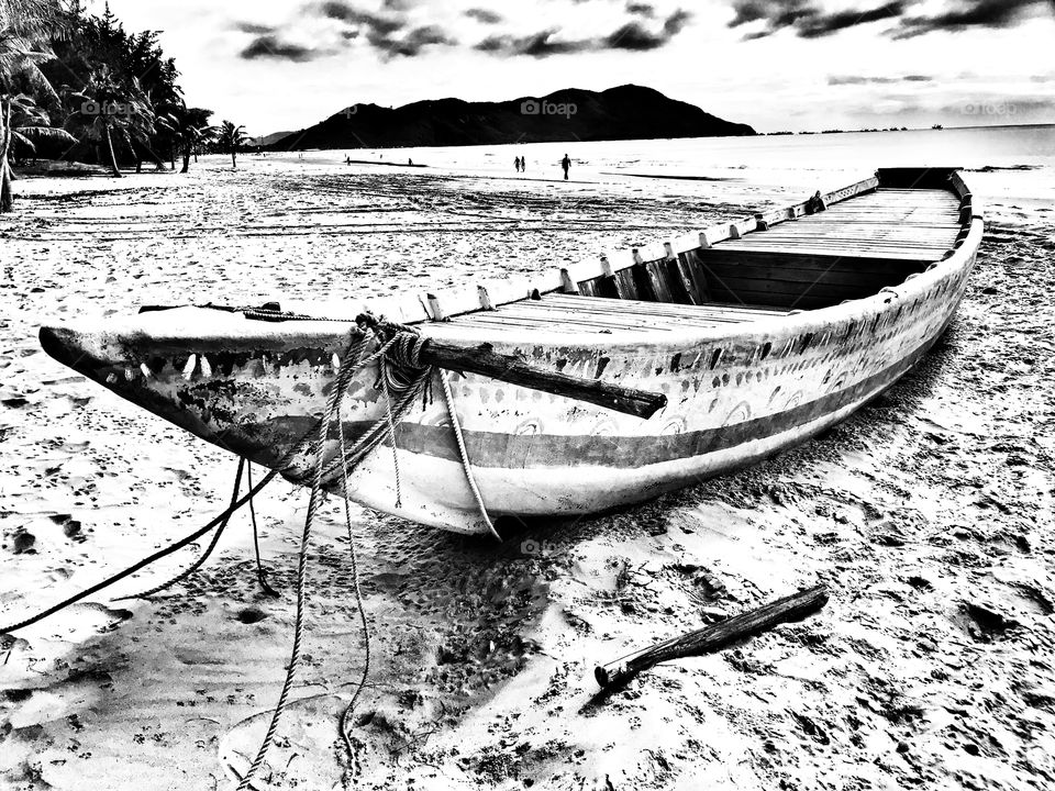 Black and white graphics of a boat at the beach