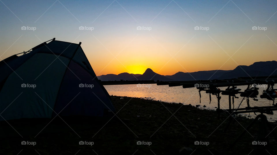 sunset from behind a tent while fishing