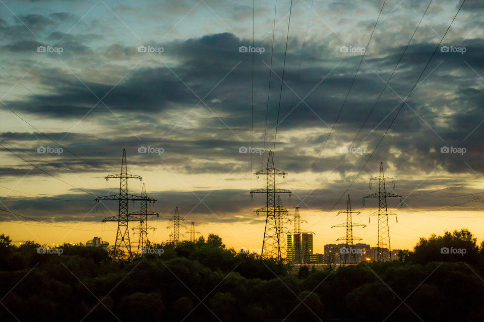 wired sunset. electricity transfer towers in Moscow suburbs
