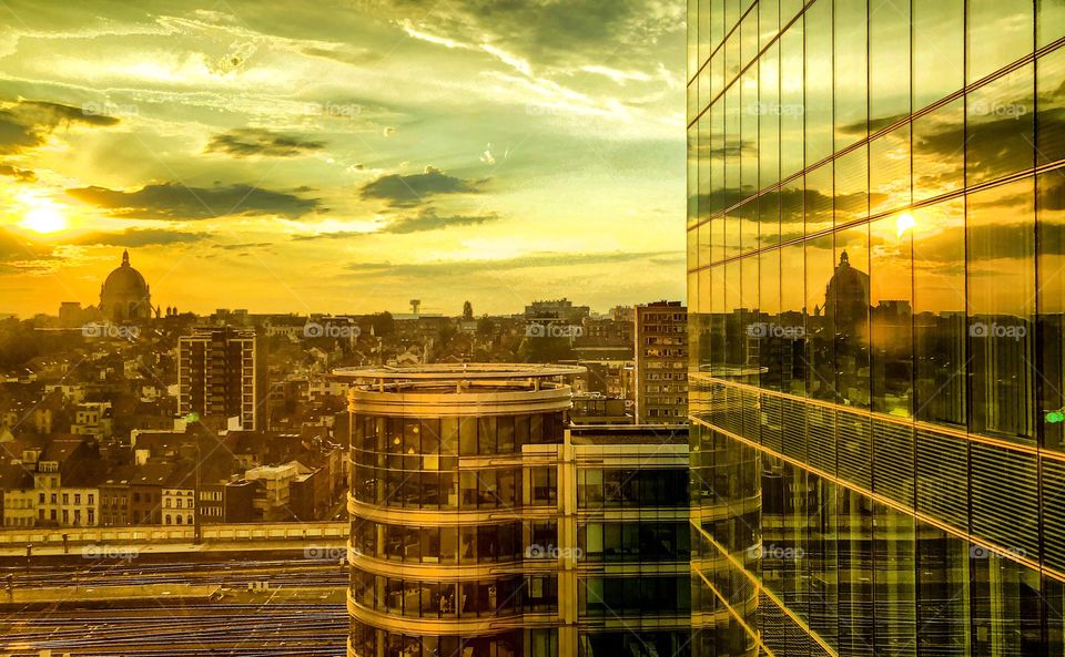 Early morning sunrise in a dramatically and colorful sky, reflected in the glass of an office building in the financial district of the city