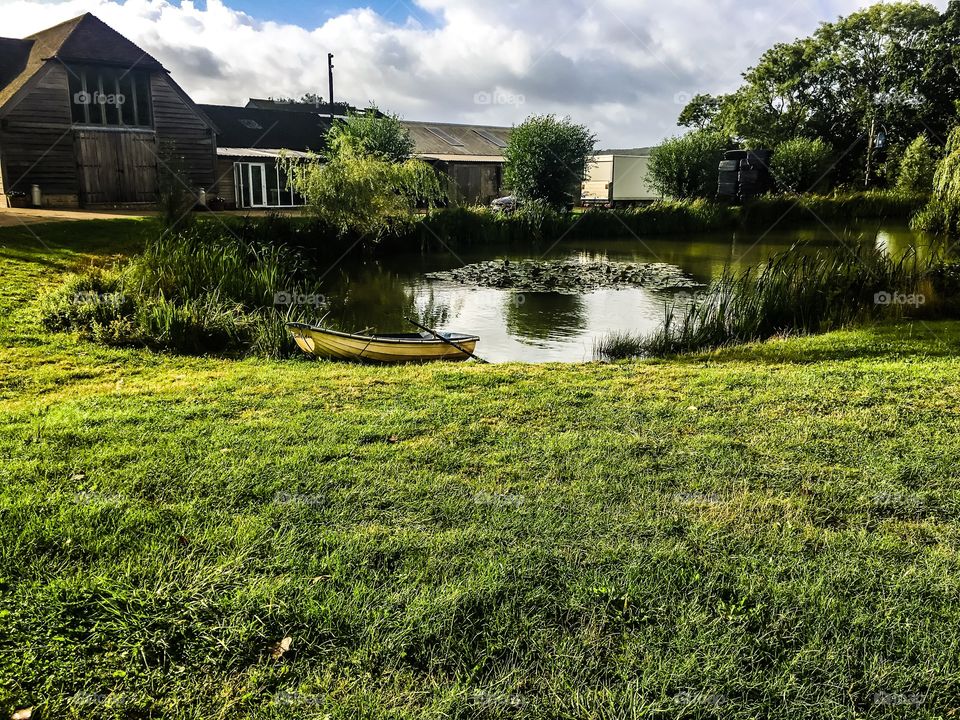 Boat on pond near wooden houses