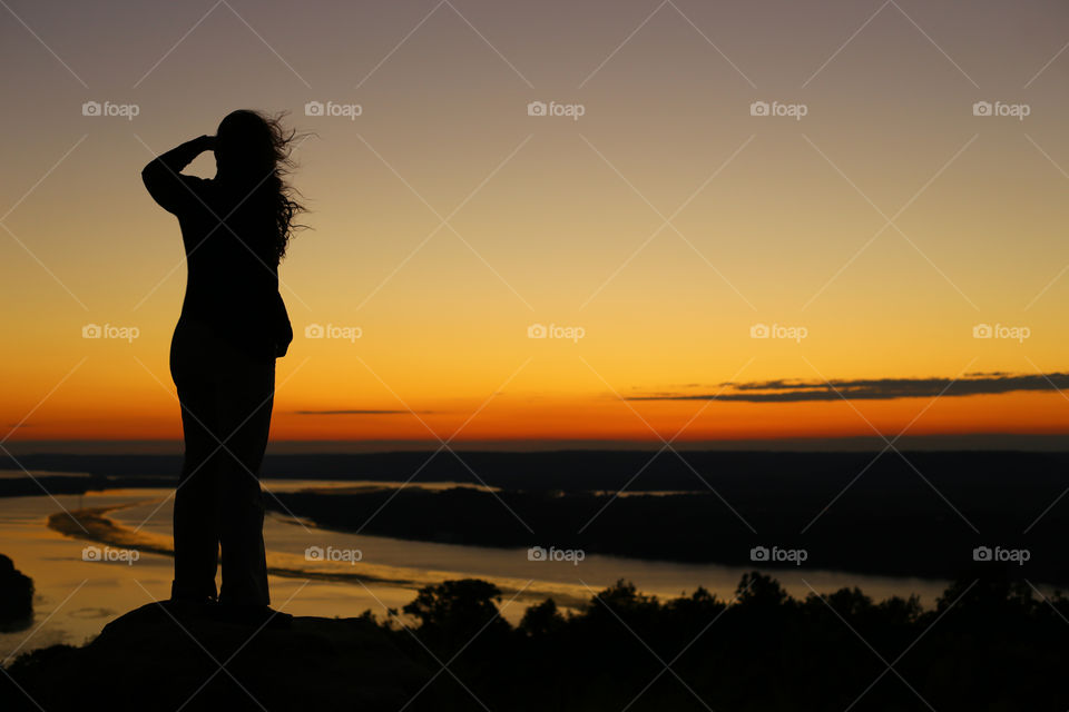 Woman overlooking a River during Sunset