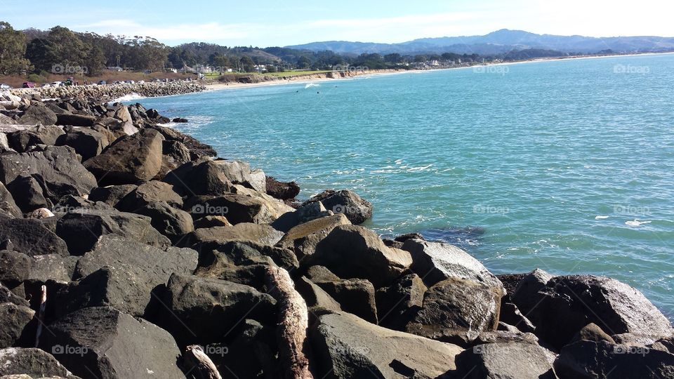 Rocky shore in Half Moon Bay, California overlooking a bright, blue ocean