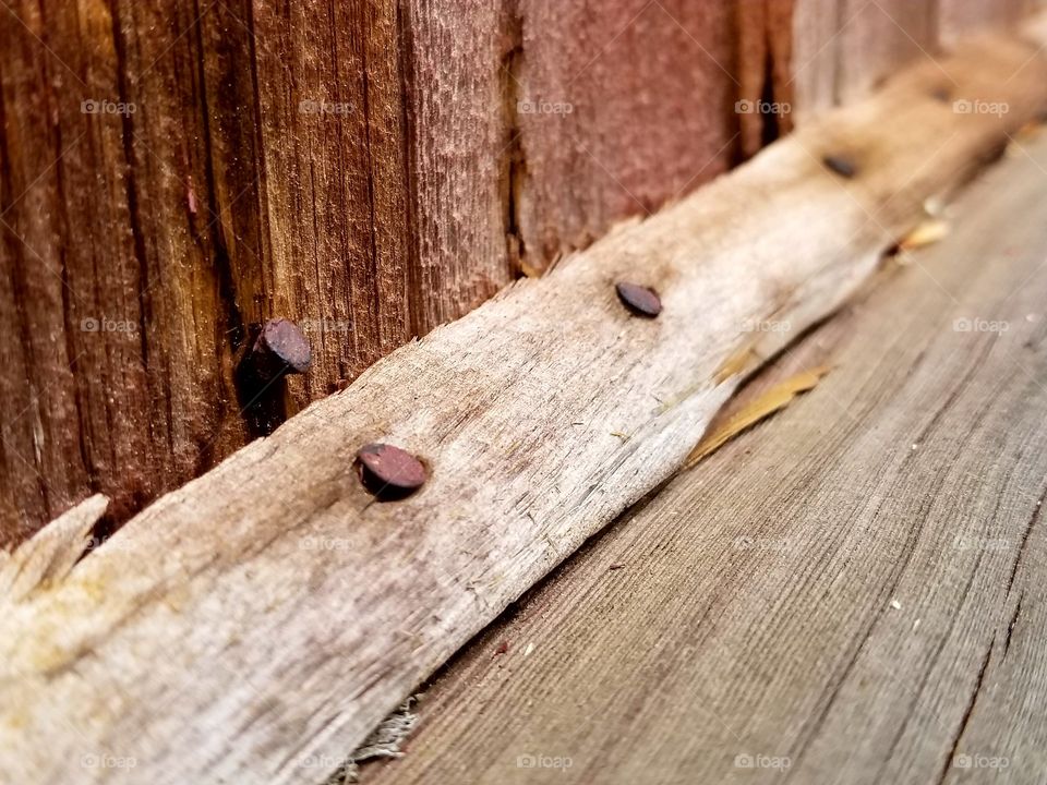 Rusty nail on damaged wooden plank