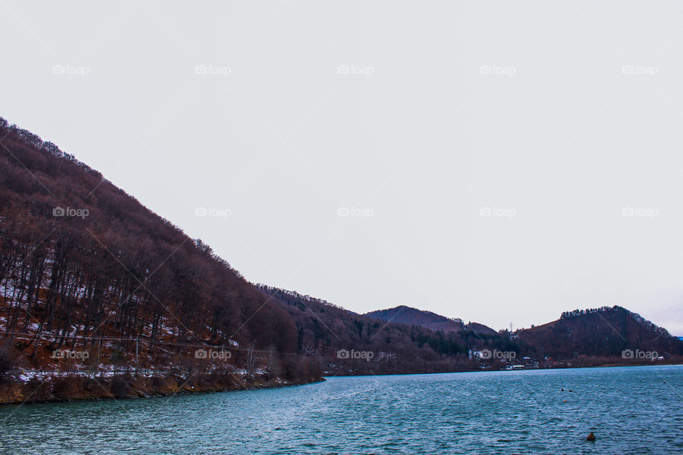 Beautiful winter landscape of the lake with mountains in Piatra Neamt, a city of Romania.