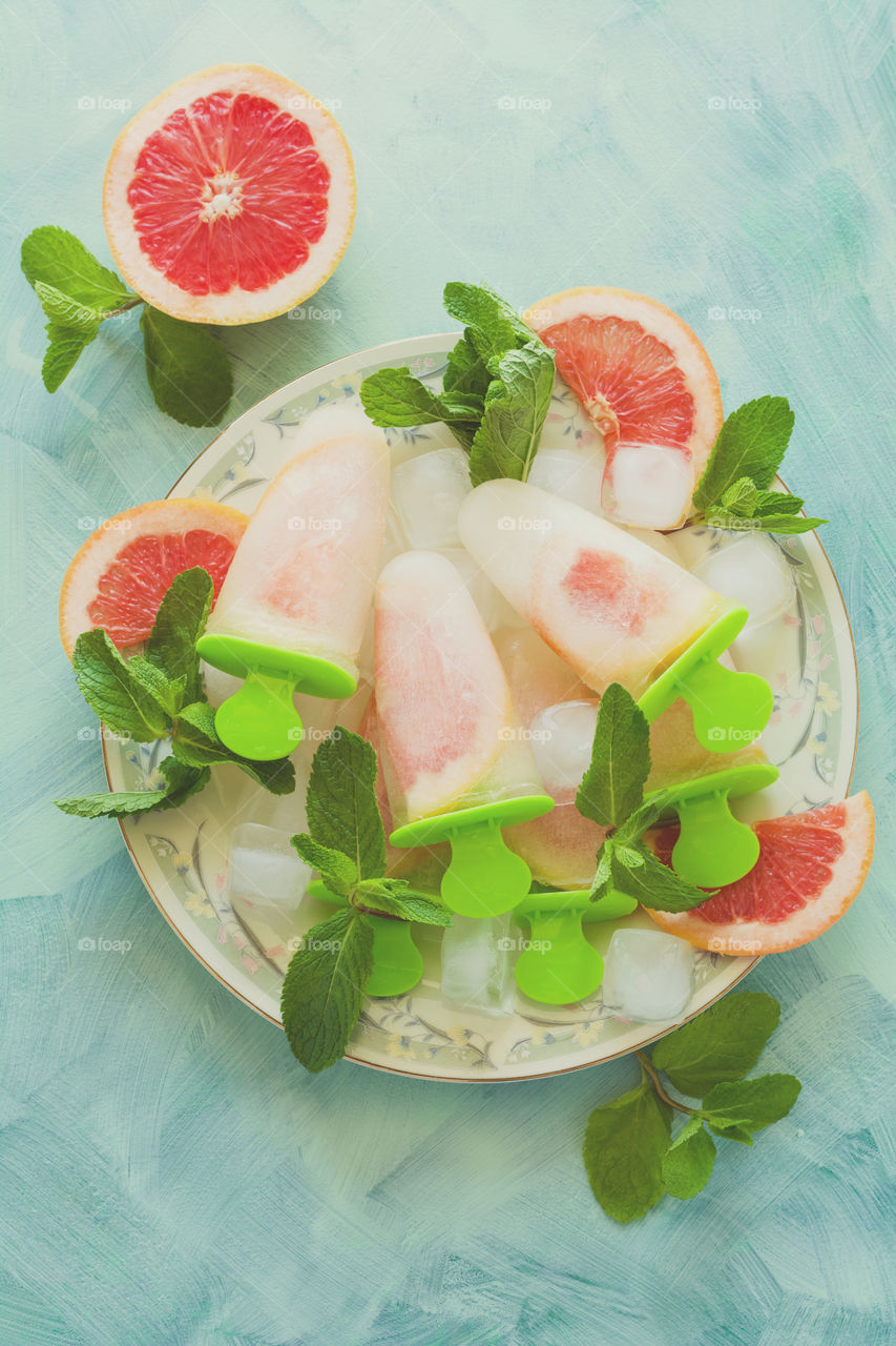 Homemade grapefruit popsicles with ice and mint