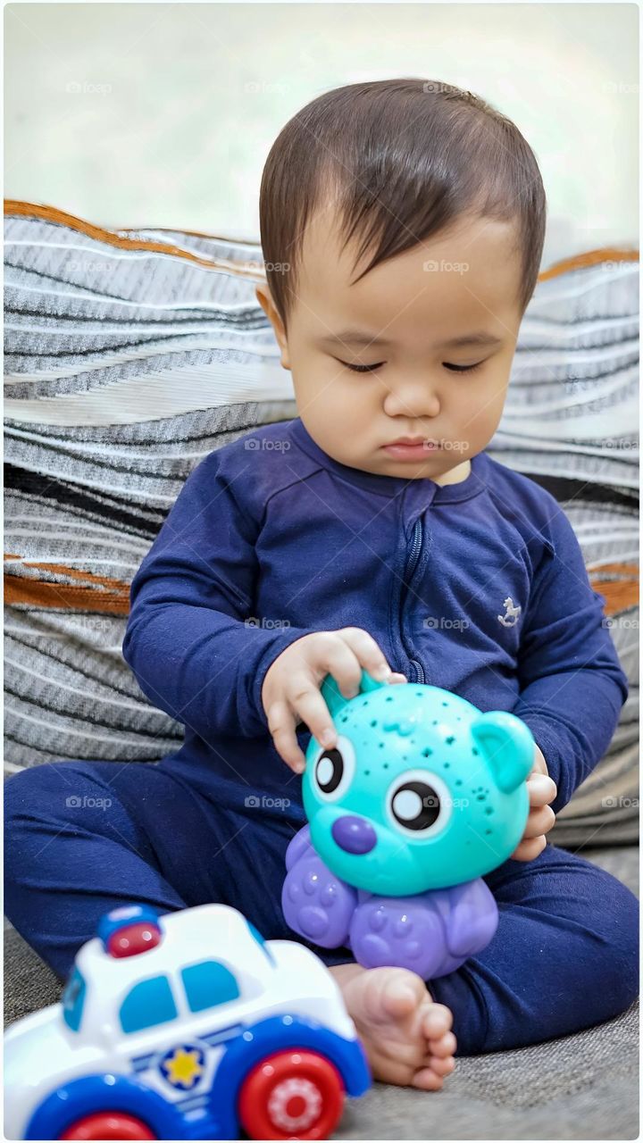 Cute Asian baby boy with his favorite toys