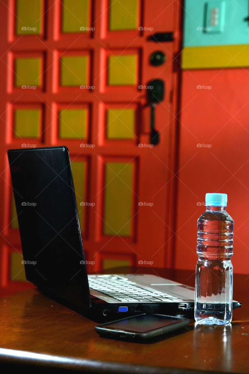 laptop computer, bottled water and smartphone