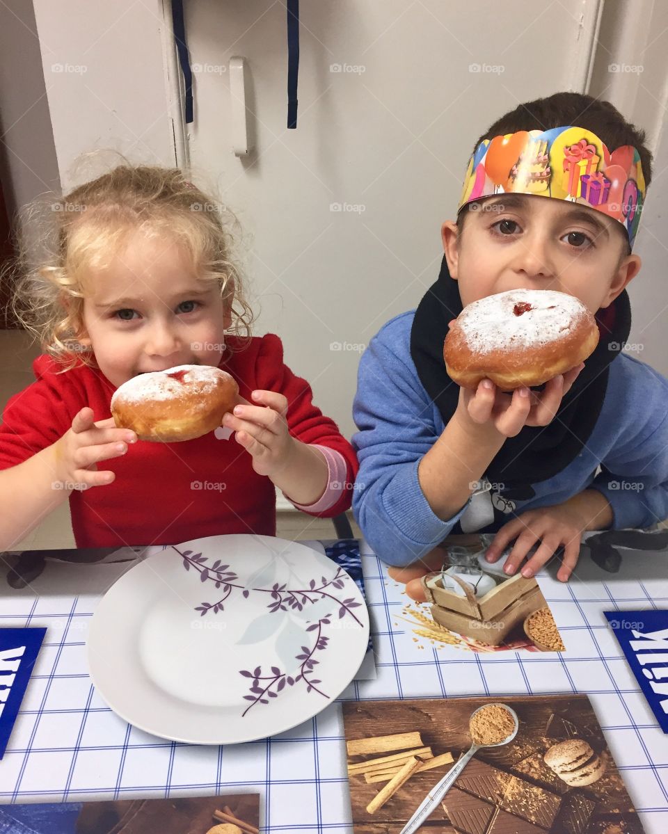 Brother and sister eating breakfast on table