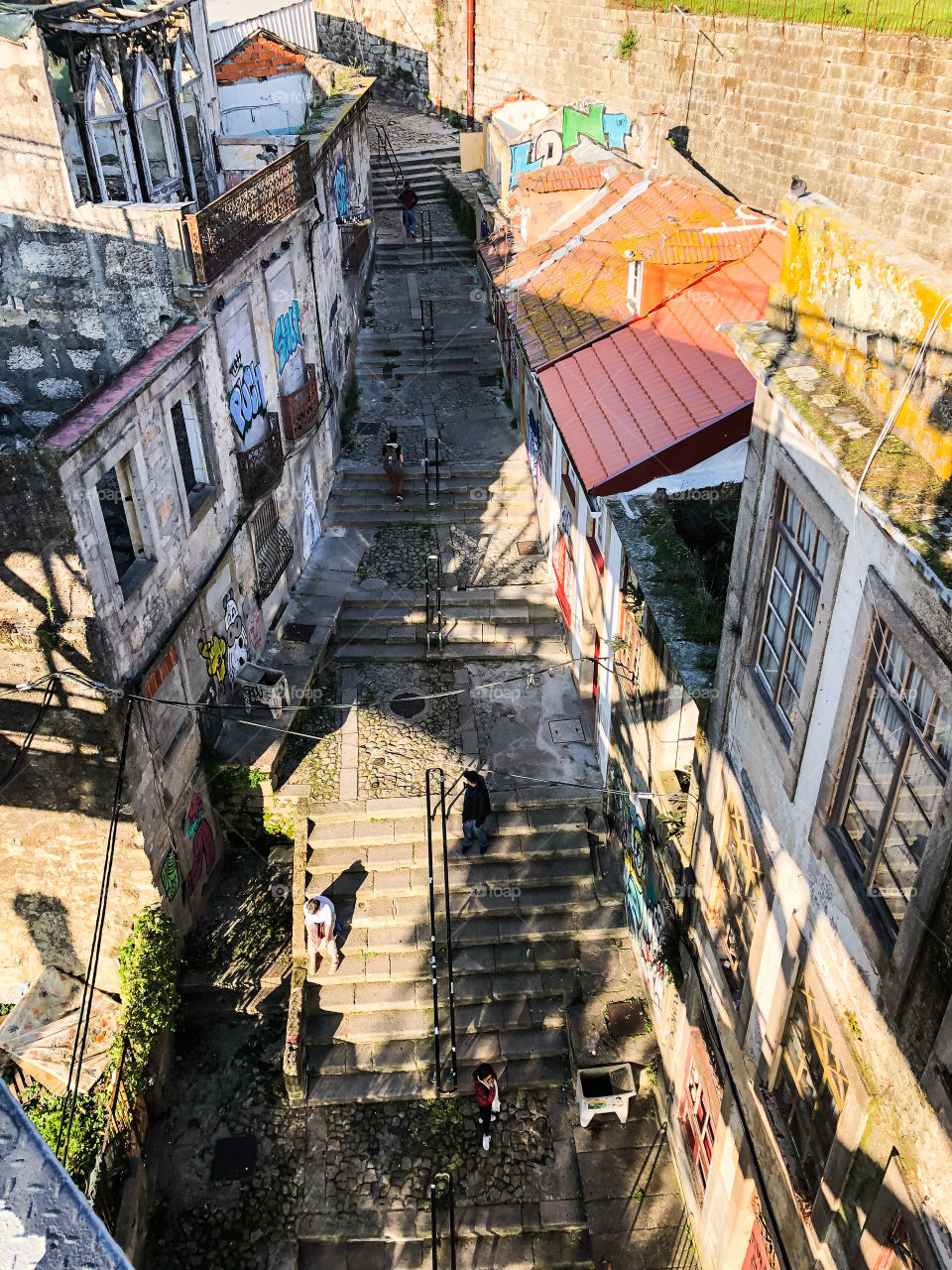 A downward view over a narrow stepped street in Porto during the late afternoon - Oct 2019