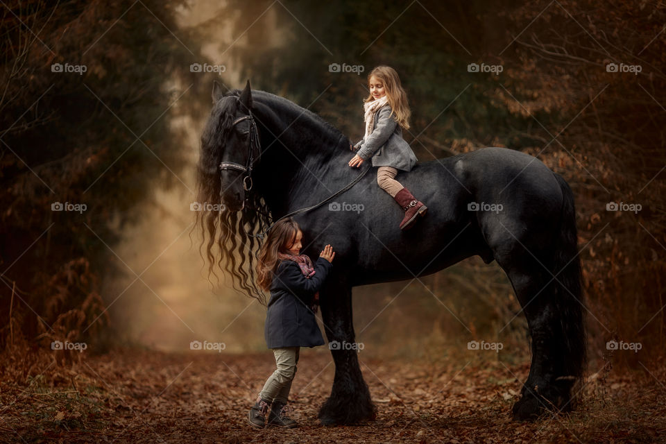 Portrait of little sisters with  horse