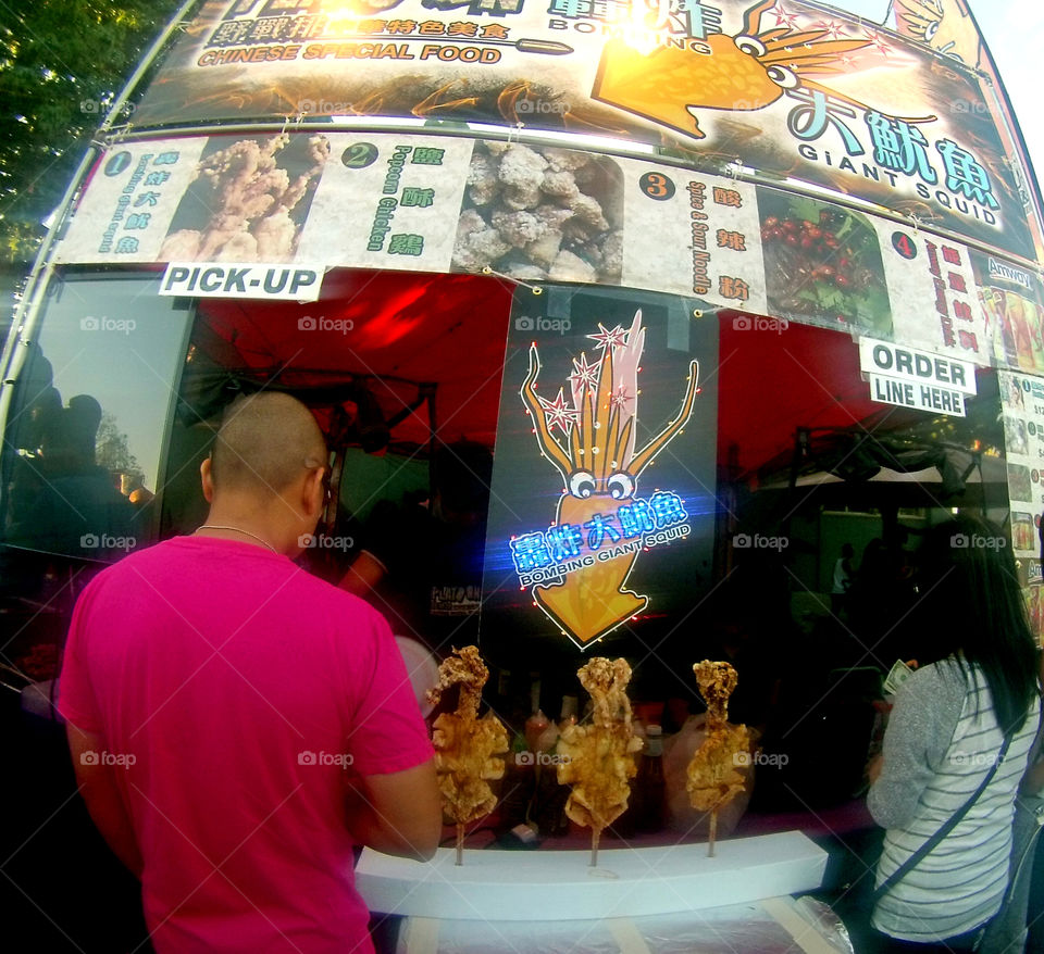 Giant fried squid calamari in a stick food booth