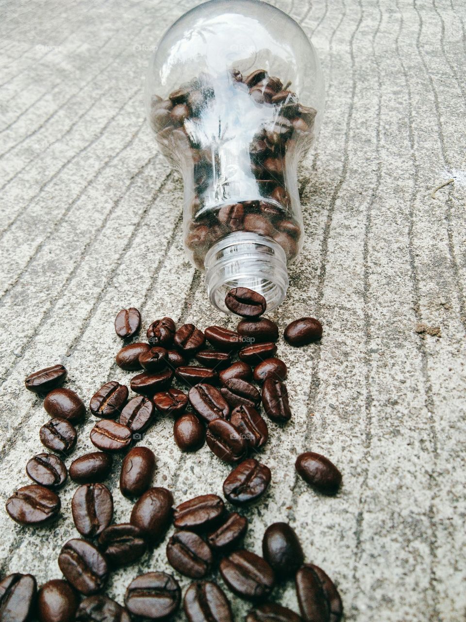 coffee beans in glass bottle on concrete floor