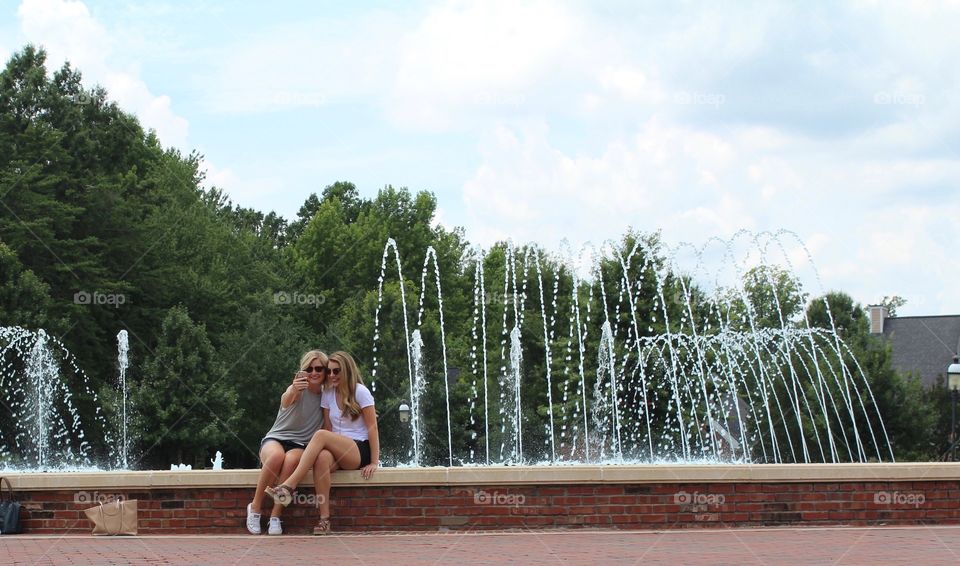 Friends taking photos by a fountain!