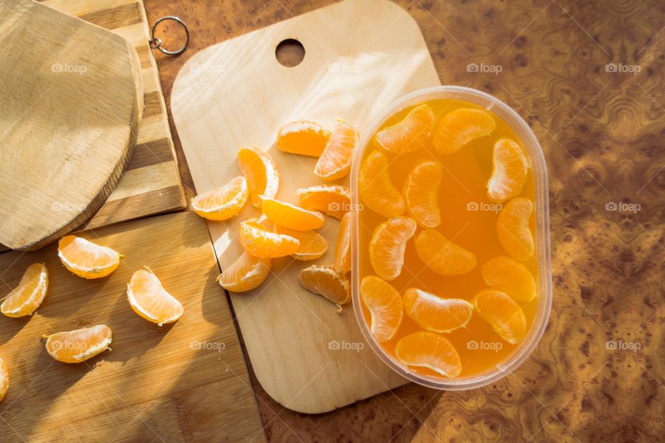 Delicious orange jelly with tangerine slices in a container and jelly worms.