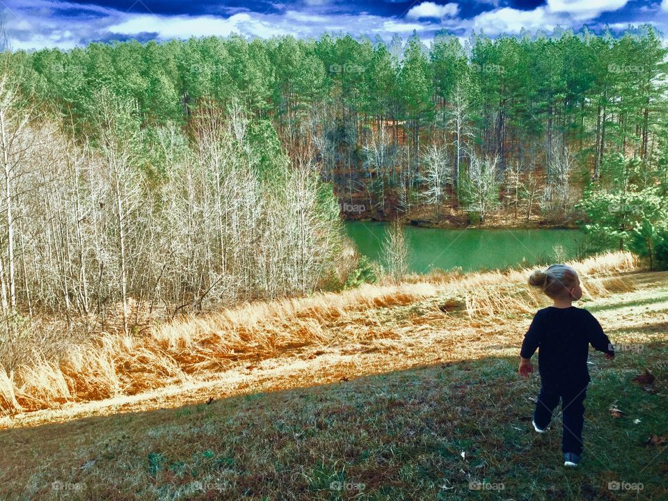 Walking to the pond, toddler with toddler bun in Southside Virginia
