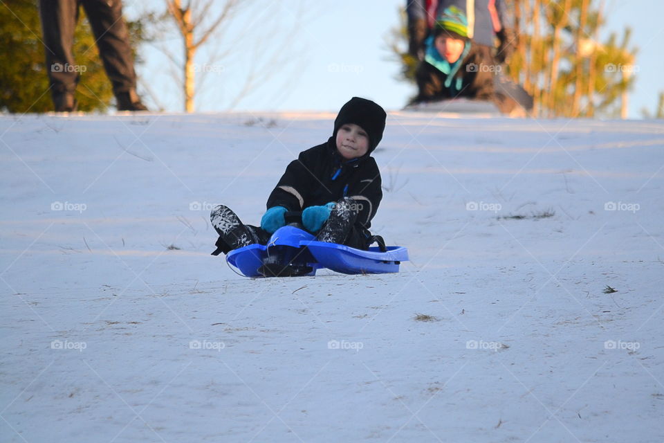 Children sledding down the hill