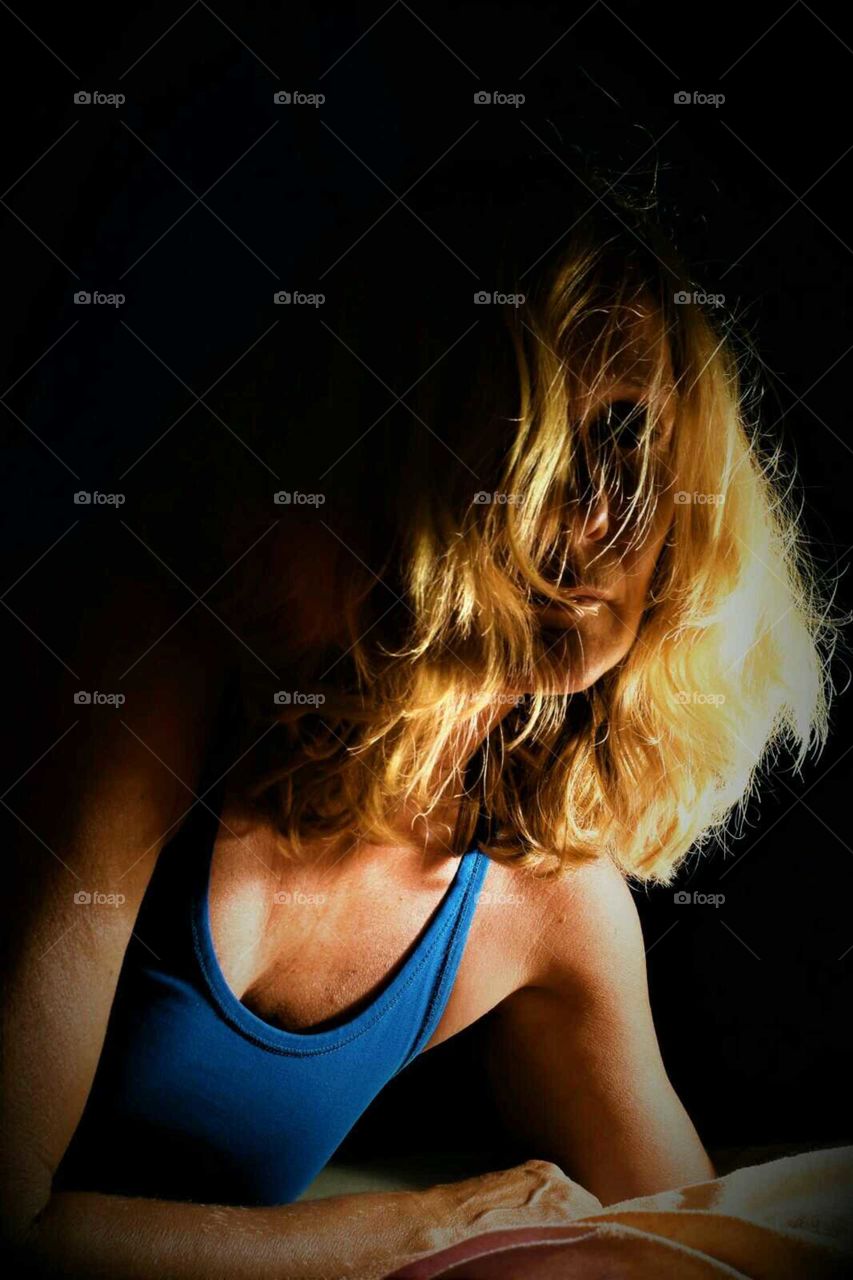 low key color portrait woman with wild blond curly hair