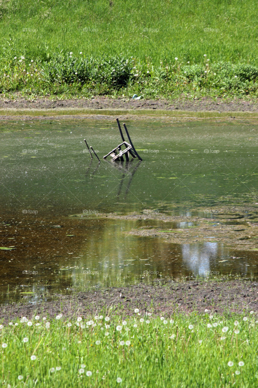 Chair upside down in pond