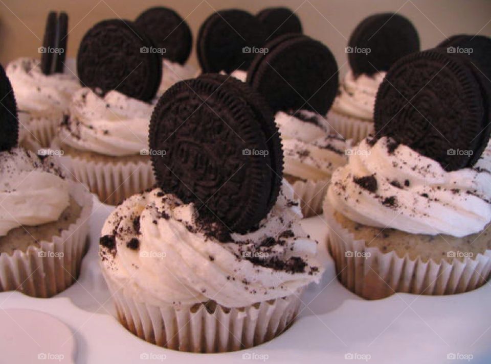 Vanilla cupcakes with a chocolate cookie on top.