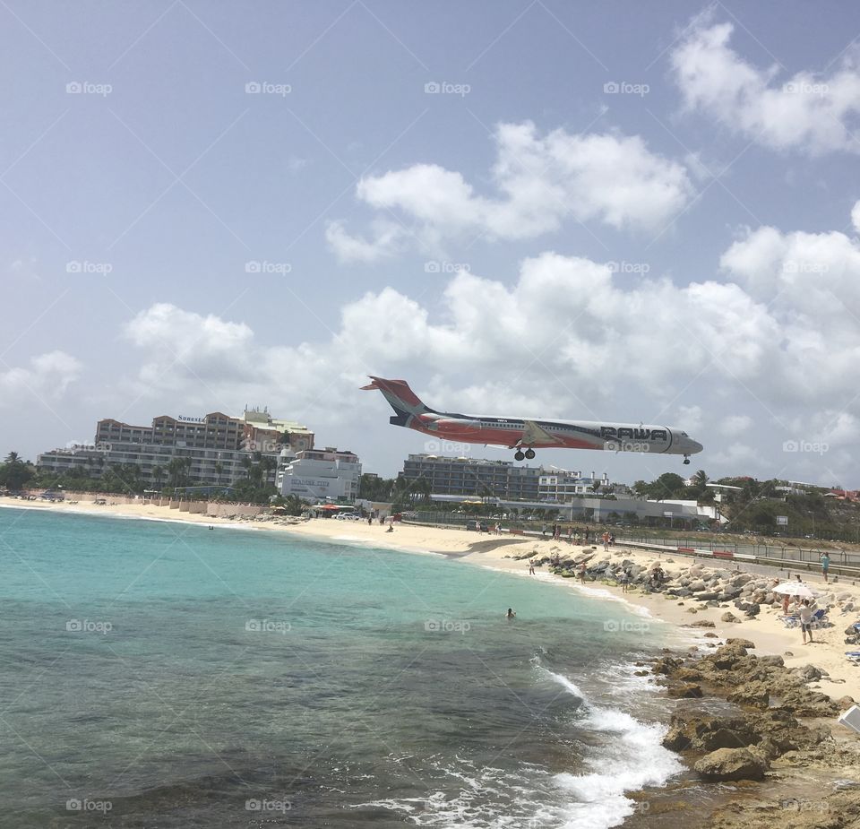 Large plane landing over beach 