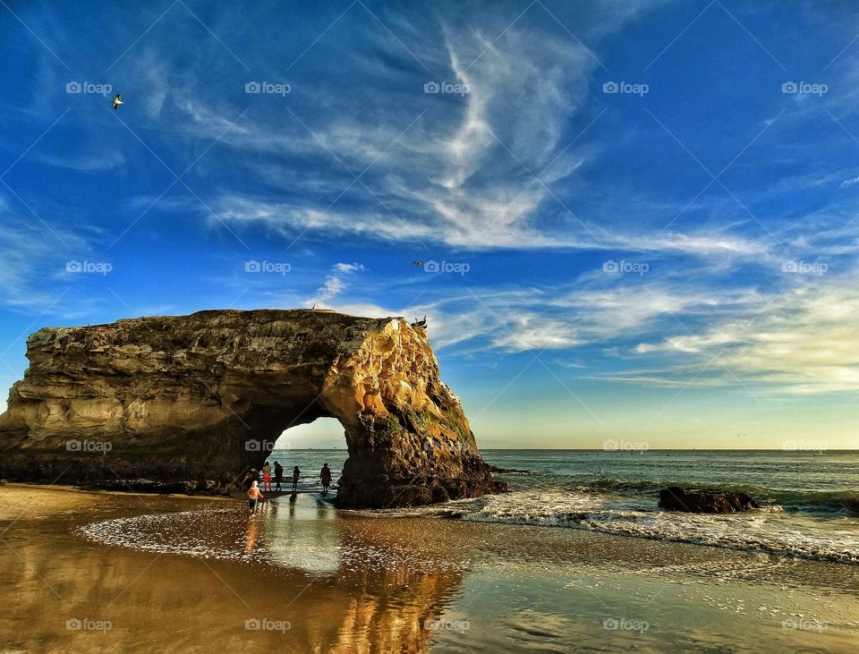 Natural Archway At Sunset. Beach Rock Archway During The Golden Hour
