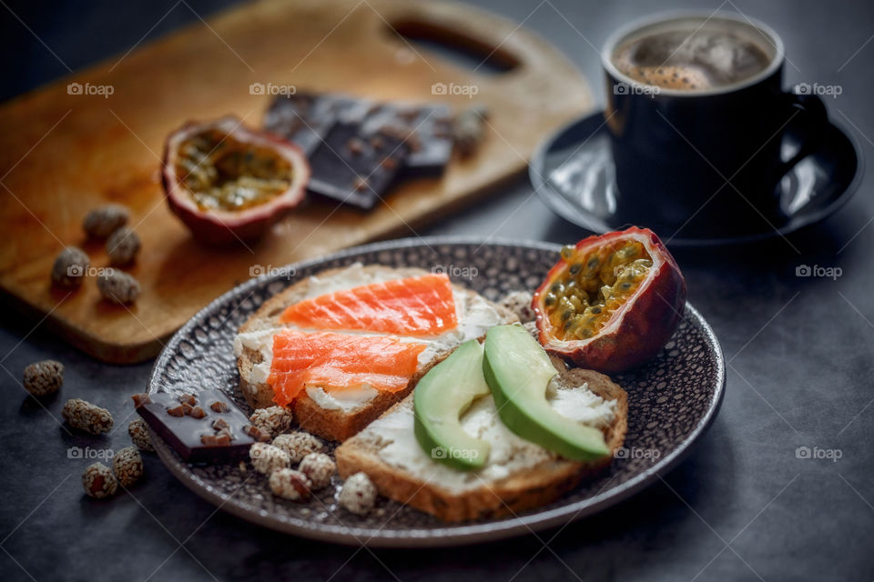 Dietary sandwiches of grain toasts with cream cheese, fish, avocado and passion fruit 