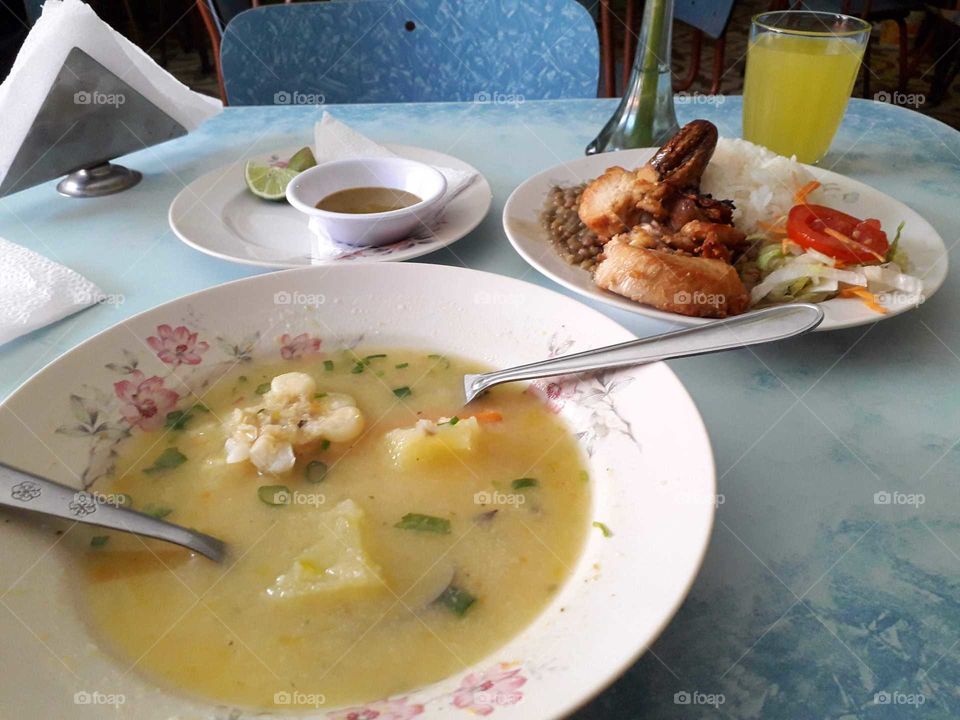 Soup with corn, chicken, salad, rice and juice.
