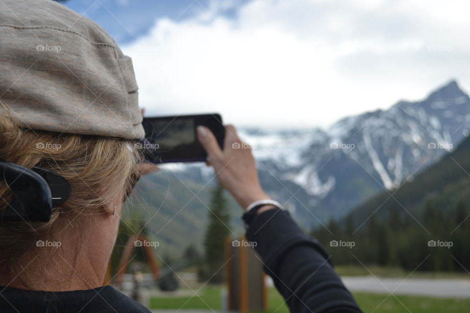 Woman photographing Rocky Mountains in Canada 