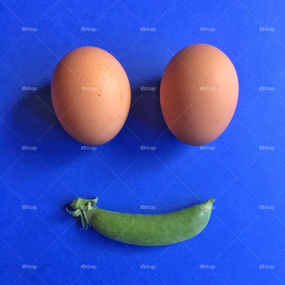 Two eggs and a bean pod in a smiley face 