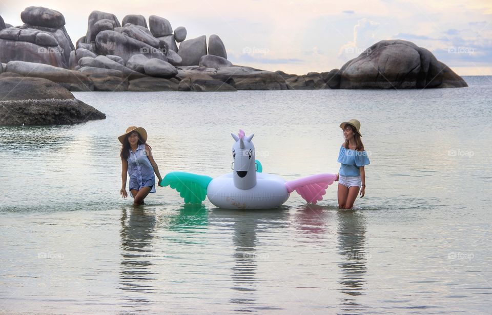 Two young woman with inflatable on sea