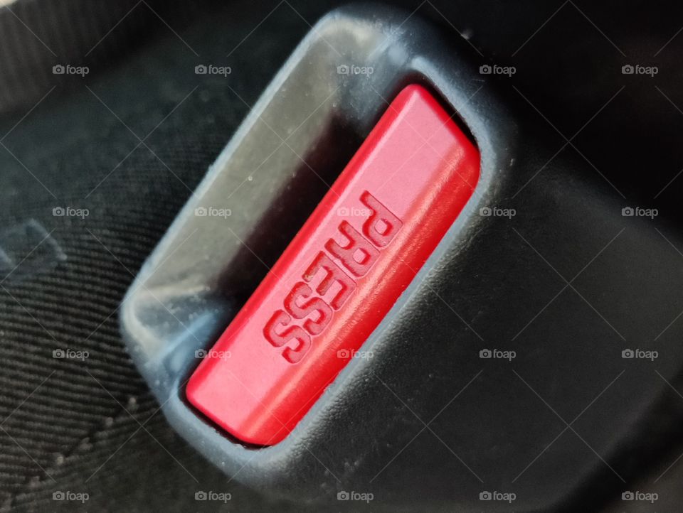 Detail zoom on shiny red seat belt button