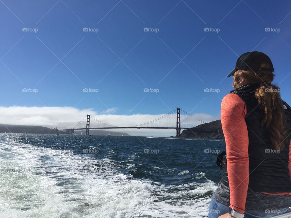 A ferry commuter enjoying the view of the Golden Gate Bridge during her commute.