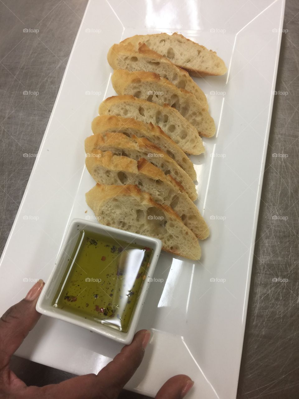 Sliced, crispy, homemade baguettes with infused garlic olive oil
