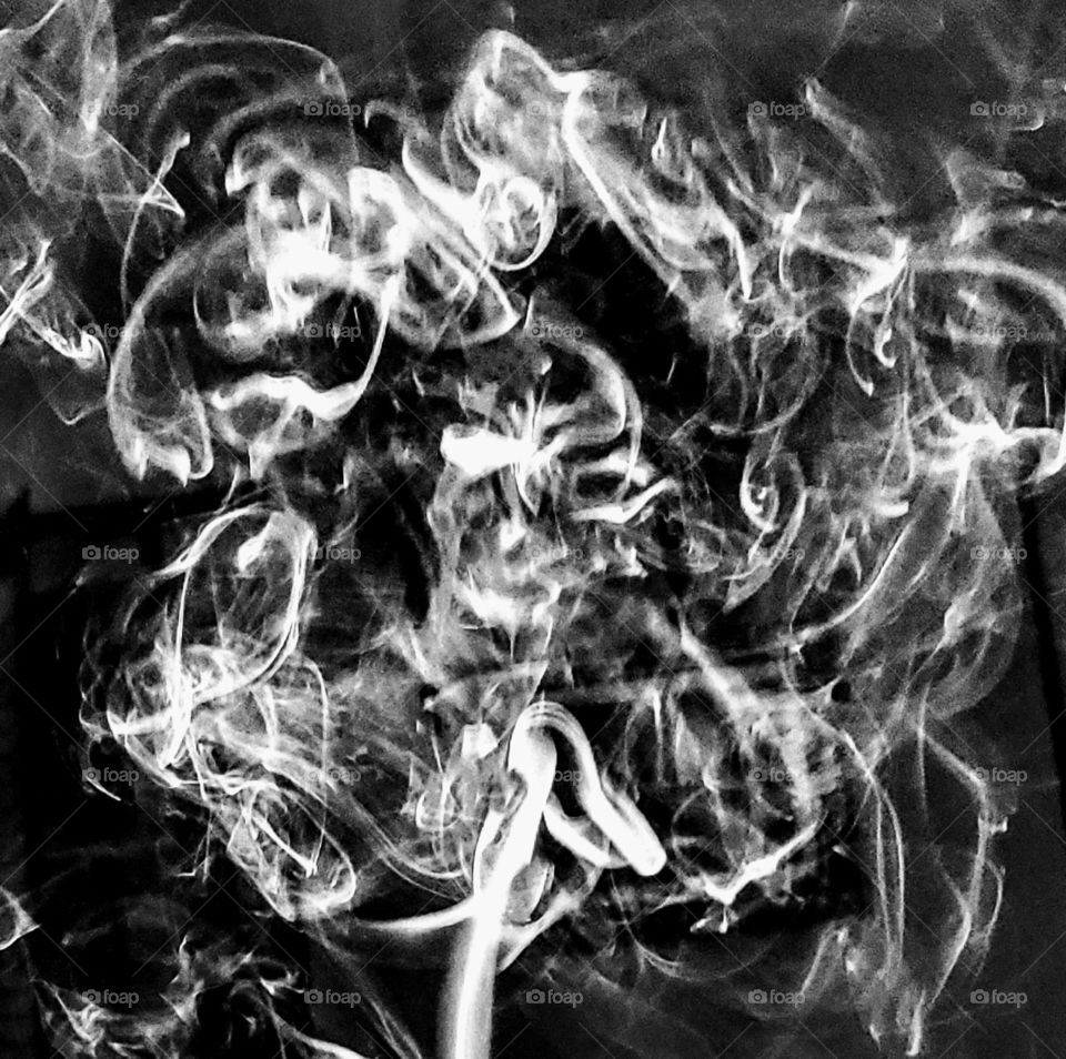 B&W, monochromatic skull💀 seen in smoke ring flowing & billowing up into the still air.