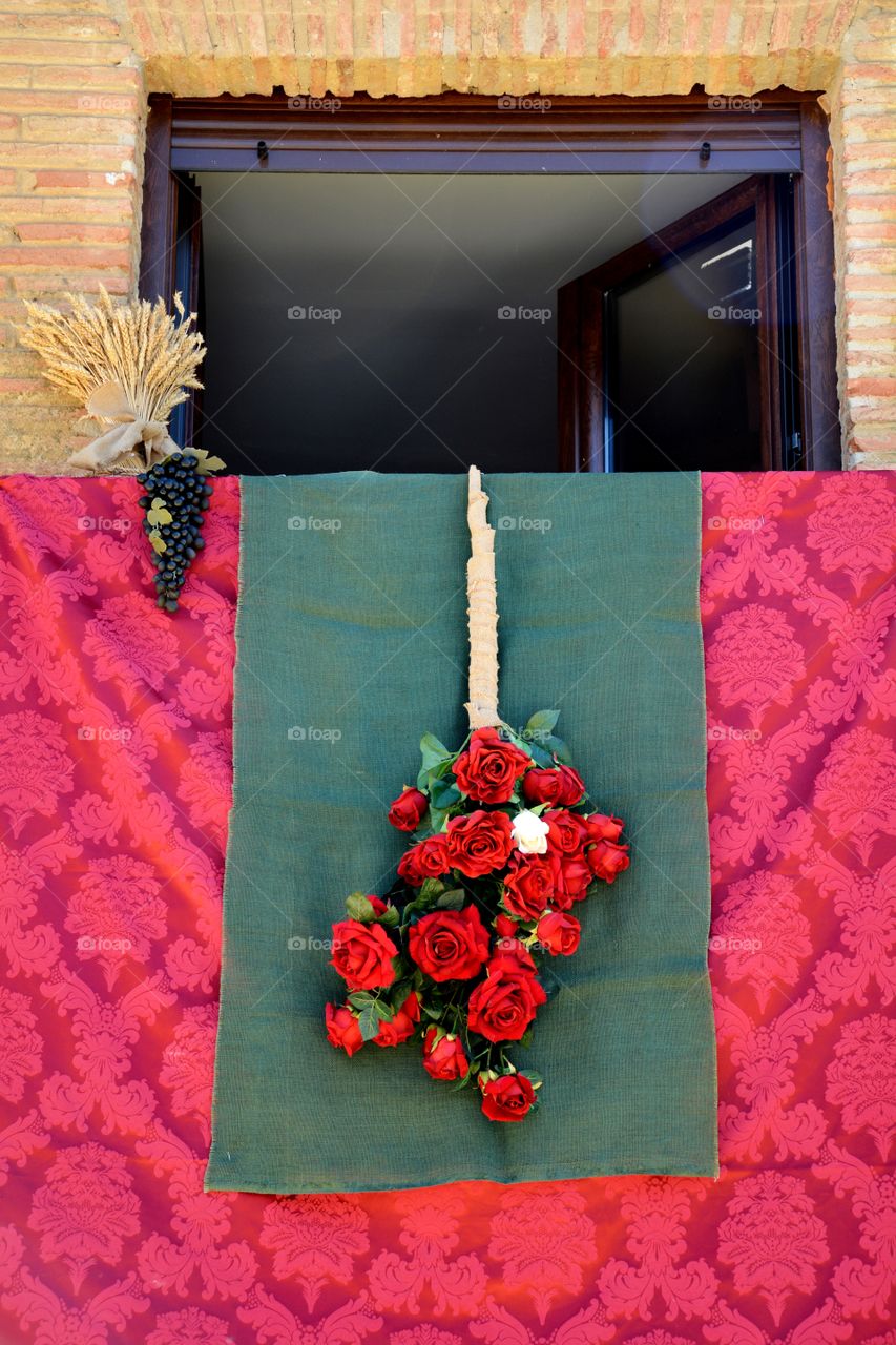 a bunch of red roses hanging of a balcony