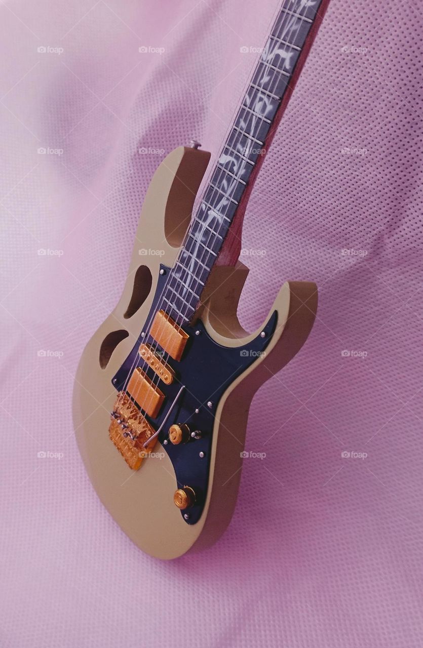 guitar miniature inside the pink shoping bag.