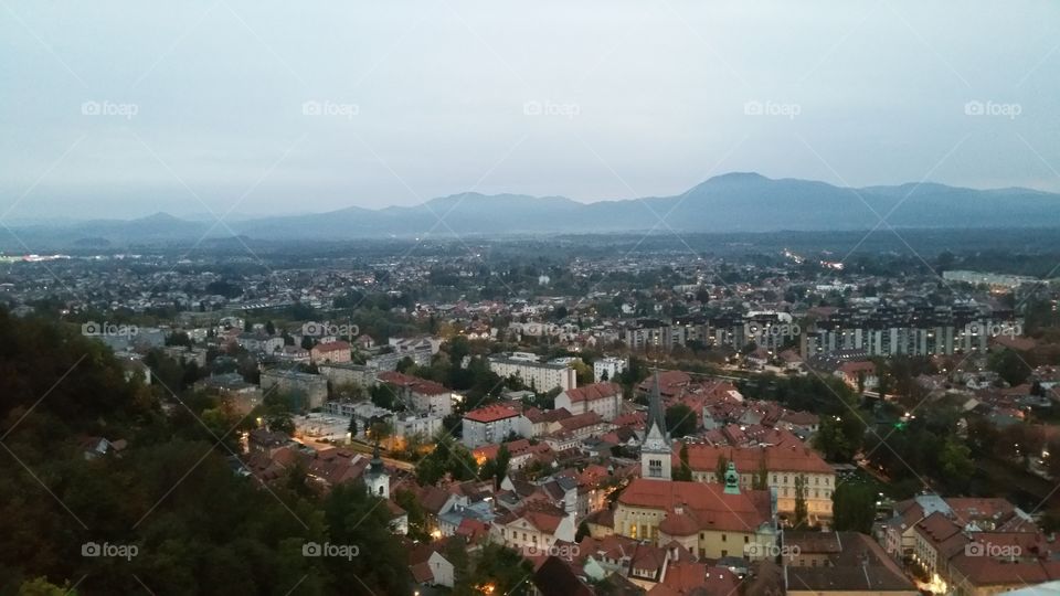 slovenia by night. ljubjana castle. scenic mountains. misty. roof tops. historic, cultural