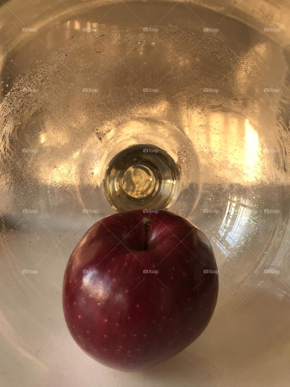 A red apple surrounded by the loving light of the sun.