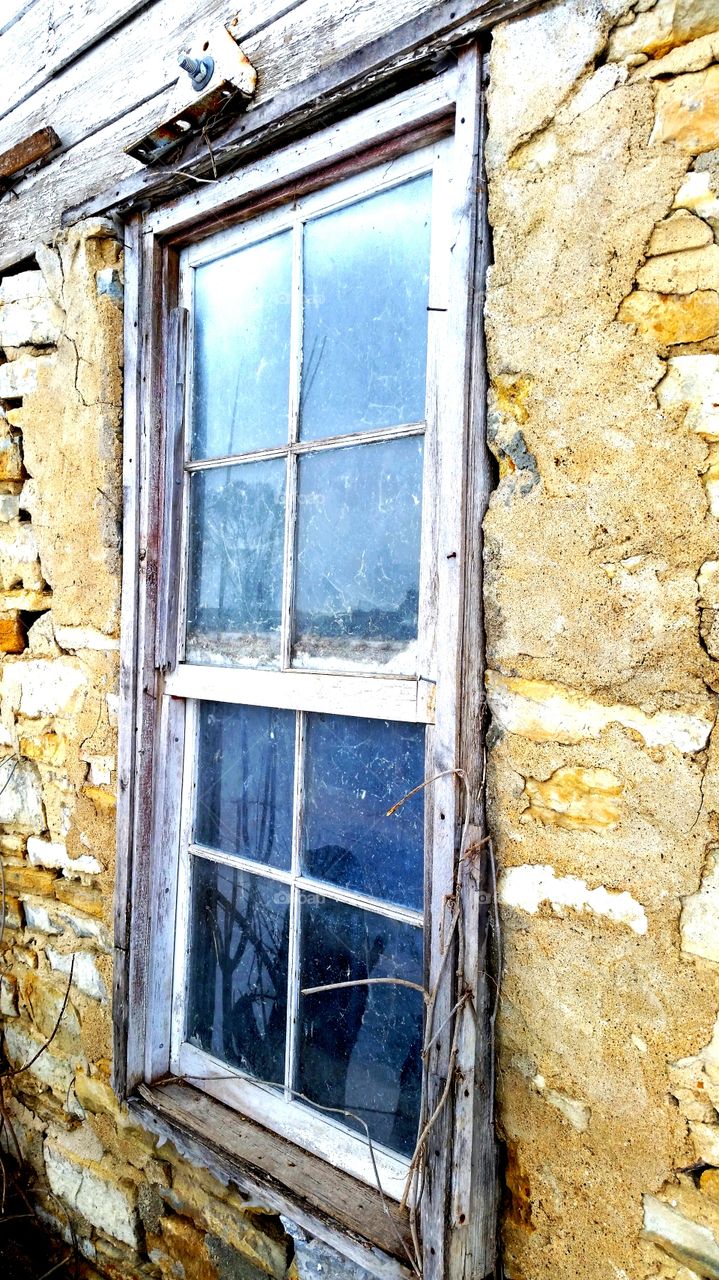 dying window. This window is in an old decrepit barn. Soon it will be torn down to make room for commercial property.  It still welcomes light to shine through and longs for someone to stare out. I wonder the stories it could tell if had the chance.