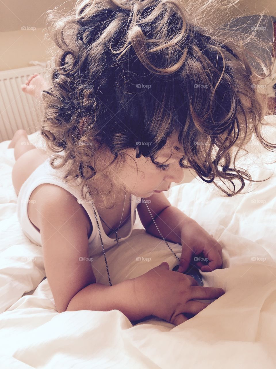 Toddler girl lying on bed