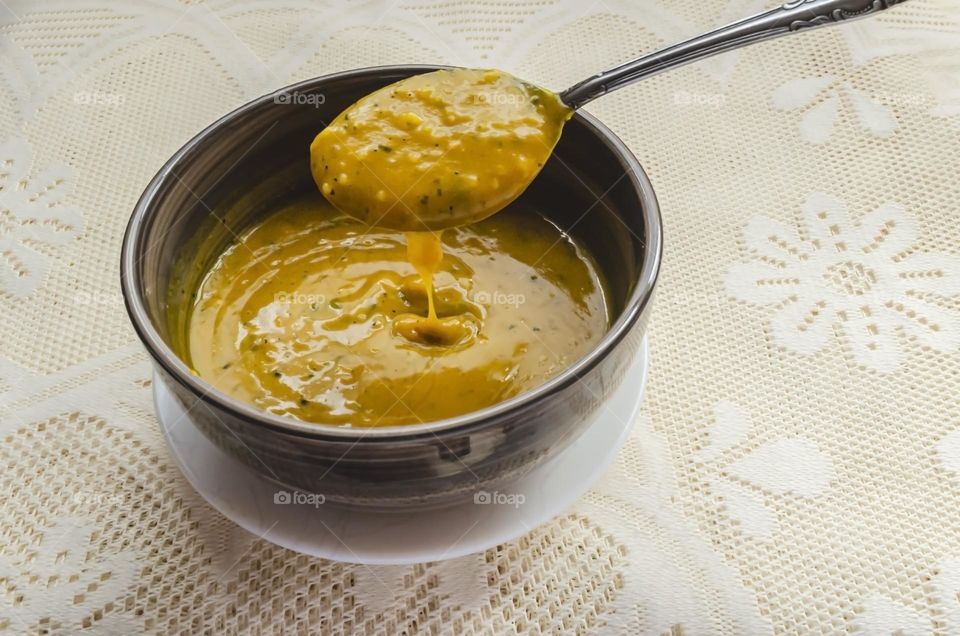 Spoon Lifting Pumpkin Puree From Soup Bowl